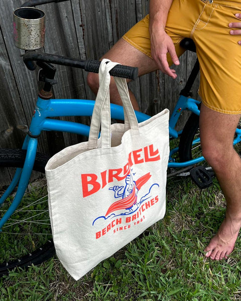Surfin' Birdie Tote hangs on the handle-bar of a bicycle.