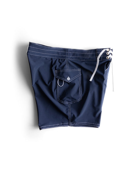 806 SurfStretch Side Pocket Boardshorts in navy, featuring white stitching, a drawstring waistband, and a buttoned back pocket, displayed flat on a white background.