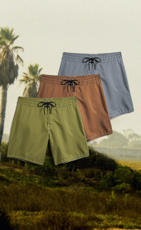 New 300 Boardshorts in Army Green, Tobacco, and Slate. Background of a hill with palm trees.