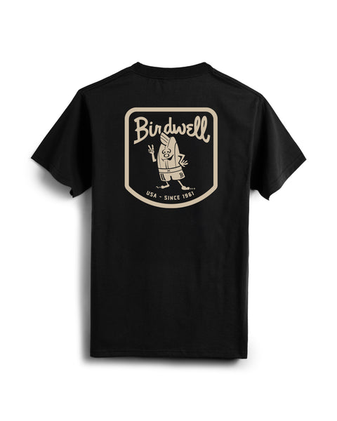 Black t-shirt with screenprint of Birdwell in script with Birdie Holding a peace sign with USA - Since 1961 below on the back. Product on white background.