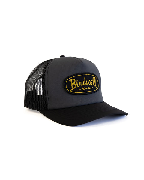 Black hat with BIRDWELL yellow logo on the front with a white background