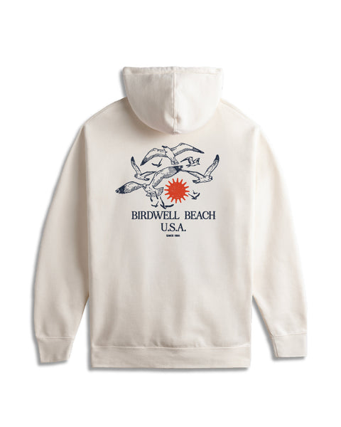 Bone hoodie with 'Birdwell Beach U.S.A.' graphic with seagulls and red sun on the back against a white background