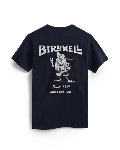 Flatlay of Navy T-Shirt over White Background. Cream colored screenprint shows Birdwell logo with birdie holding up a peace sign with 