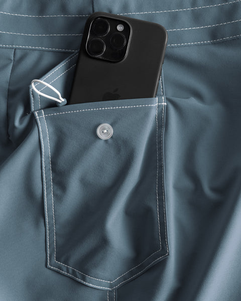 Side pocket with black iphone sitting halfway out of the pocket. White Key Loop on left of pocket.