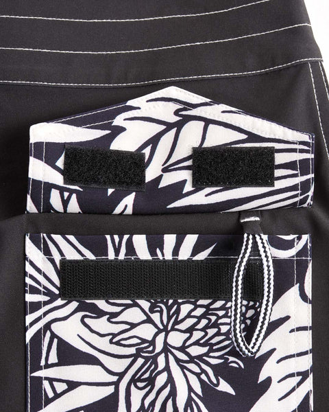 Back pocket with velcro closure and key loop featuring black and white floral pattern.