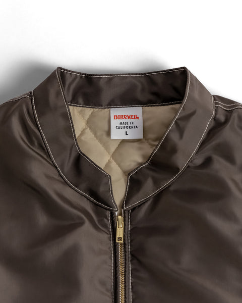 Close-up of Birdwell Quilted Racing jacket in brown with the racing collar with a Birdwell label on the interior a white background