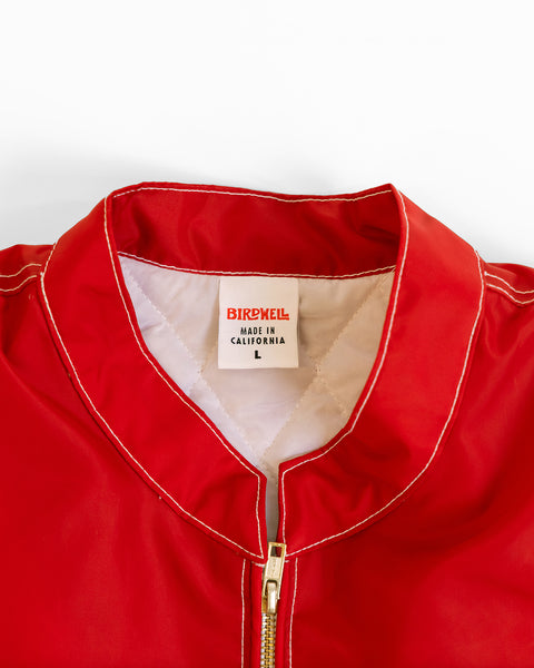 Close-up of the red Racong jacket with a brand label size tag that says 