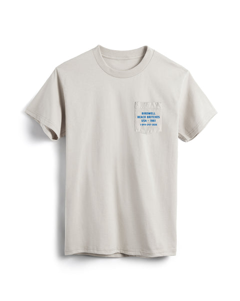 Beige t-shirt with a small pocket and text on a white background