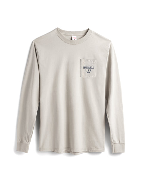 Beige long-sleeve shirt with a small logo on a white background