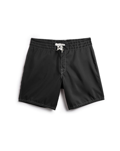 300 Boardshorts - Black: Featuring white stitching, a white drawstring waistband, and a simple, classic silhouette—shown against a white background. These water-repellent boardshorts are proudly made in the USA for reliable quality.