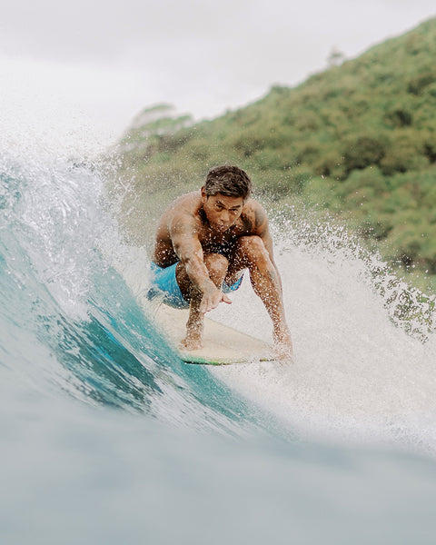 Man surfing on a wave with a scenic background