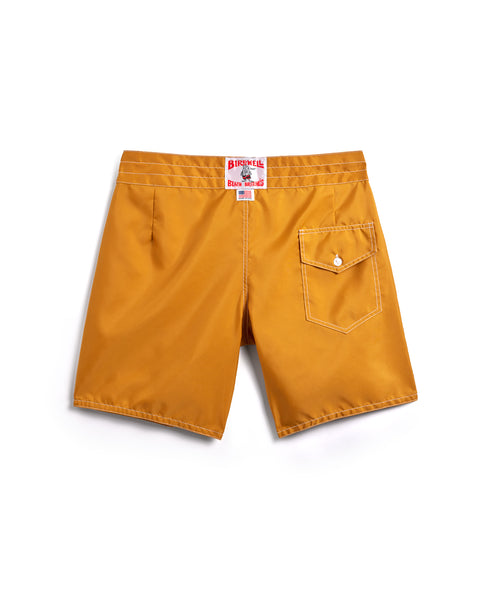 Mustard yellow shorts with a brand label on a white background