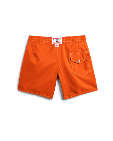 Orange shorts with a brand label on a white background