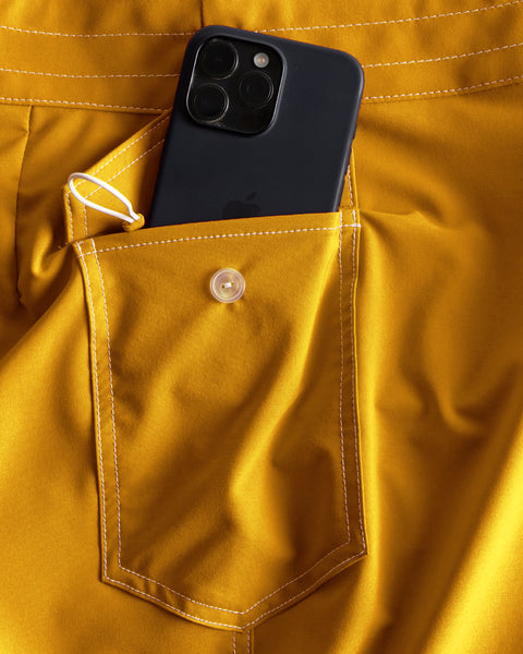 Black phone in a yellow pocket of a jacket