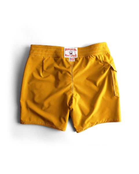 Yellow shorts with a brand tag on a white background