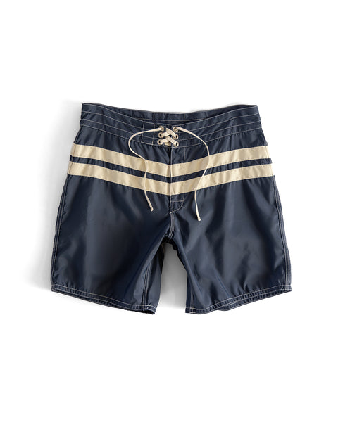 Navy blue board shorts with two beige stripes on a white background