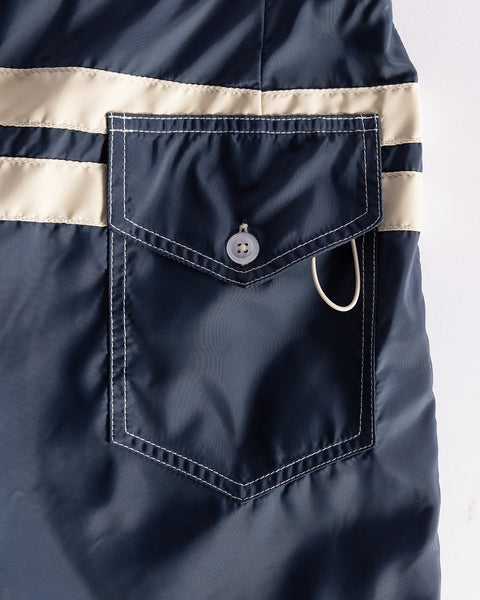 Navy blue jacket with a beige stripe and button on a white background