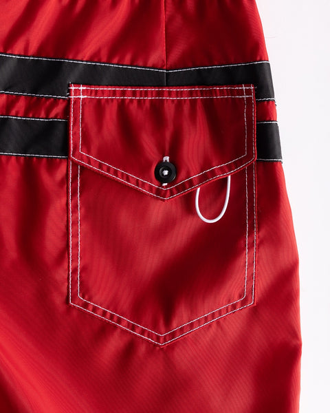 Close-up of a red pocket with black trim on a garment.