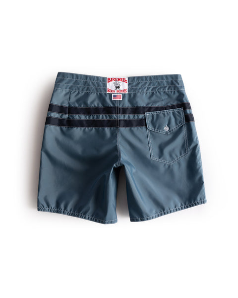 Blue shorts with a brand label on the back pocket against a white background