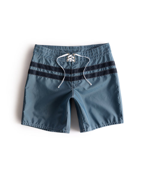 Blue swim shorts with black stripes on a white background