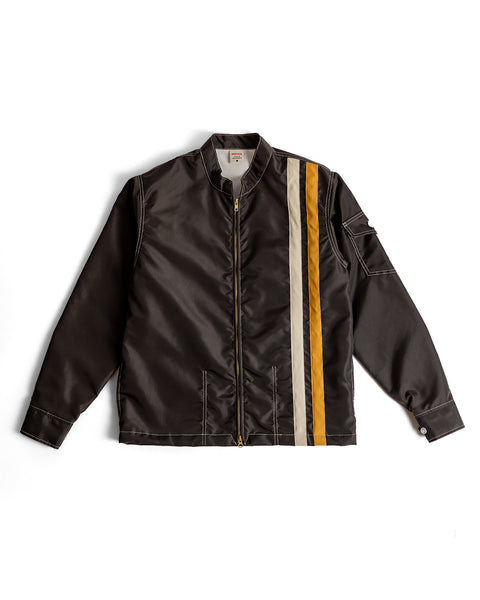 The Racing Jacket 26 in Brown/Bone/Gold features a front zipper, long sleeves, a small collar, a left sleeve pocket, and classic American-made details. Three vertical stripes in gold, bone, and brown accent one side for a stylish finish.