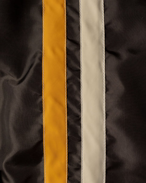 Close-up of fabric from the Racing Jacket 26 - Brown/Bone/Gold, American-made with three vertical stripes in gold, bone, and brown. The smooth, slightly shiny material resembles classic SurfNyl polyester used in racing jackets.