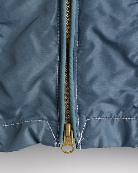 Close-up of the Racing Jacket 26 in Federal Blue/White/Orange, made in the USA, featuring a gold center zipper, white seam stitching, and a light blue SurfNyl fabric lining beside the zipper.