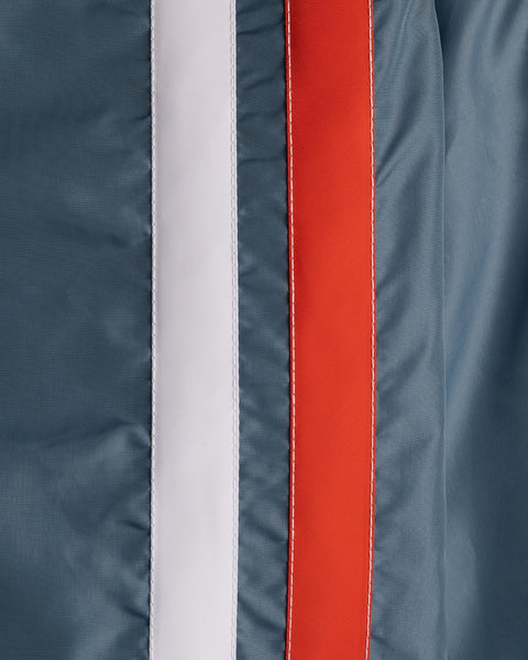 Close-up of the Racing Jacket 26 in Federal Blue with white and orange vertical stripes. Visible stitching on the orange stripe highlights this jacket’s vintage-inspired sportswear style.
