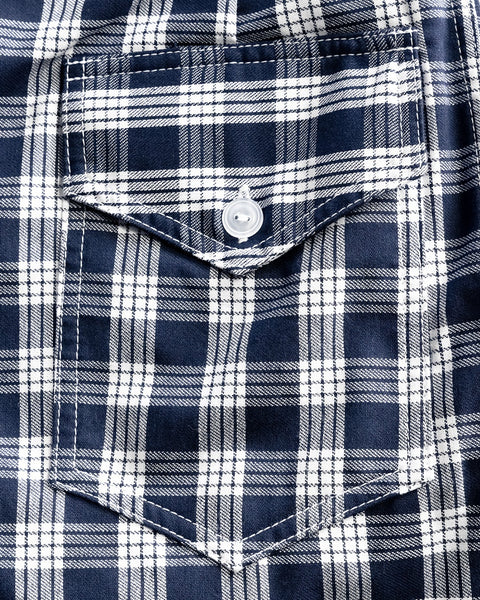 Close-up of the 310 Boardshorts in Golden Hawaii Palaka, featuring a blue and white plaid pattern with intersecting lines reminiscent of classic Hawaiian workwear and detailed with a front pocket flap and single white button.