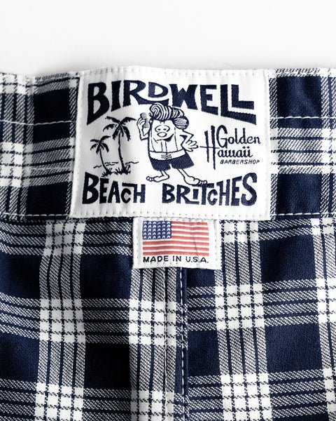 Close-up of the Birdwell Beach Britches label, featuring a cartoon and palm trees, above a 