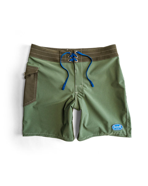 The 808 Powerbird - Olive SurfStretch boardshort, made in the USA, features a side pocket, blue drawstring waistband, and a blue and white logo patch on the front left leg. Shown laid flat on a white background.