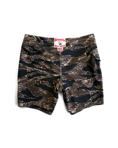 A pair of 808 SurfStretch Side Pocket Boardshorts in Tiger Camo, featuring brown and black tiger stripe print, a visible back pocket, and red label above the waistband. Displayed flat on white background. Made in the USA.