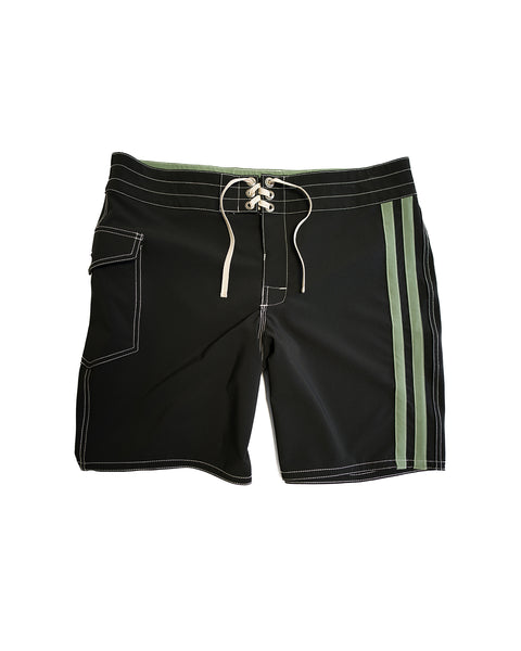 The 808 Racing Stripes - Black/Olive boardshort features white stitching, a front lace-up closure, left thigh side pocket, and two parallel olive stripes on the right. Medium-length shorts shown laid flat on a white background.