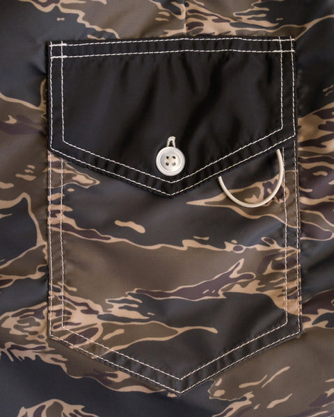 Close-up of a Tiger Camo-patterned pocket with flap, white stitching, a white button, and looped cord—classic details from the 300 Boardshorts, SurfNyl’s premium USA-made style.