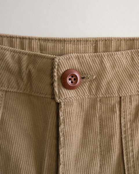 Close-up of the waistband of the Classic Corduroy Pants - Sand, crafted in Southern California with a brown button and prominent vertical stitching that showcases the rich texture and detail of the 100% cotton corduroy fabric.