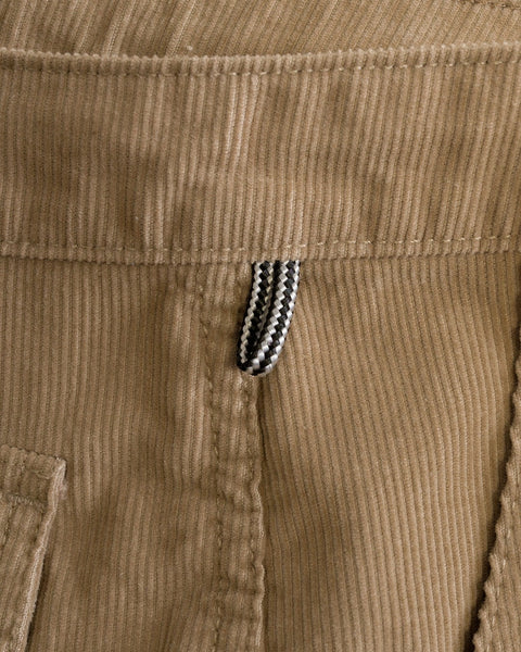Close-up of the Classic Corduroy Pants - Sand, made in Southern California from 100% cotton corduroy, featuring a striped black and white belt loop, part of the waistband, and visible stitching details.