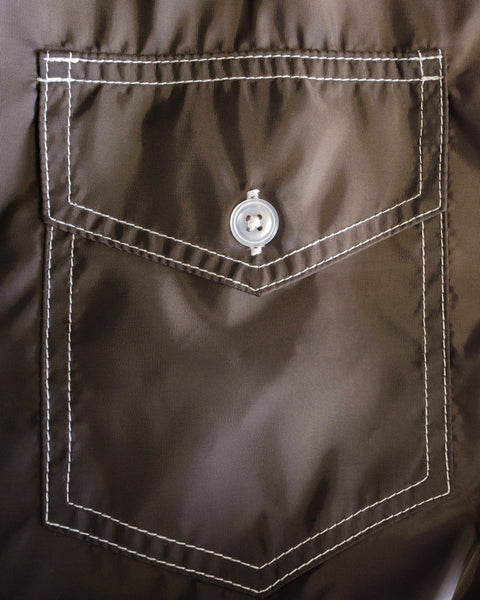 A close-up of the Racing Jacket 26 - Brown/Bone showcases a brown SurfNyl fabric pocket with crisp white stitching and a central white button on the flap, highlighting the classic American-made Racing Jacket design.