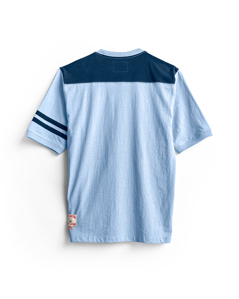 Introducing the Special Teez Champ in Arctic Blue/Navy: a premium 100% cotton short-sleeve t-shirt, proudly made in the USA. This shirt features an arctic blue base with a bold navy panel across the shoulders, two navy stripes on the left sleeve, and a small patch near the bottom hem. Shown from the back.