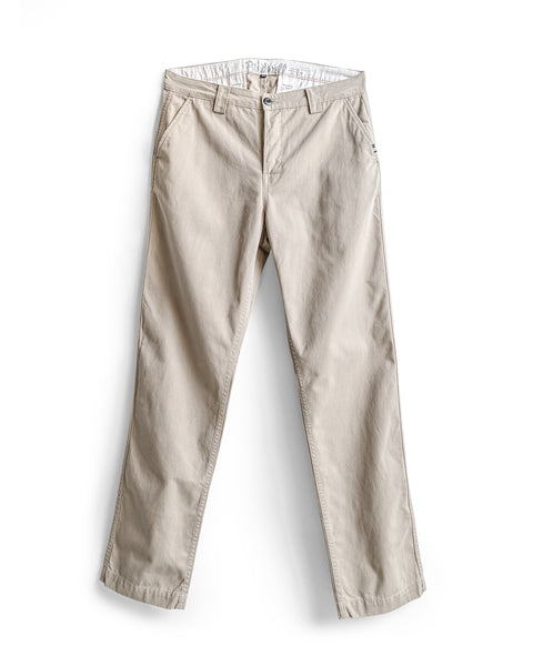 The Stockman Chino Pants in Bone are relaxed fit chinos made from 100% cotton twill, featuring front pockets, belt loops, and a button closure; they are shown laid flat on a white background.