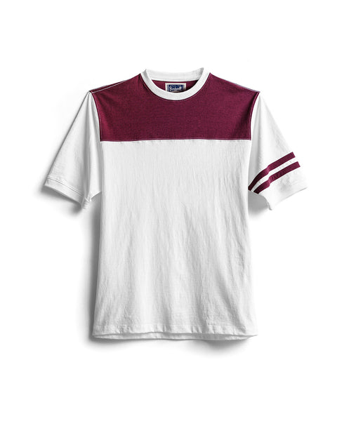 The Special Teez Champ in Vintage White/Burgundy is a short-sleeve premium t-shirt featuring a maroon yoke across the shoulders and two maroon stripes on the left sleeve. Crafted from USA-grown cotton, this relaxed fit tee offers effortless comfort and style, showcased against a white background.