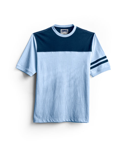 Introducing the Special Teez Champ in Arctic Blue/Navy – a premium short-sleeve t-shirt featuring a navy panel across the chest and shoulders, crafted from soft USA-grown cotton for lasting comfort. Designed with two navy stripes on the left sleeve and a relaxed fit, it offers effortless everyday style.