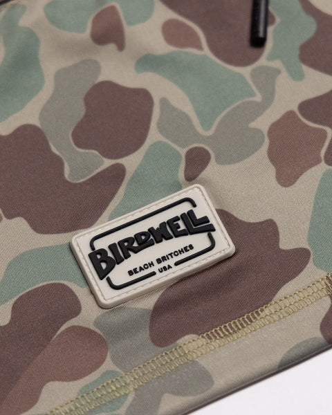 Close-up of the Sunteez Hoodie - Frogskin Camo fabric with a rectangular patch that reads BIRDWELL BEACH BRITCHES USA in black text on a white background, highlighting the quality and craftsmanship of this made in USA garment.