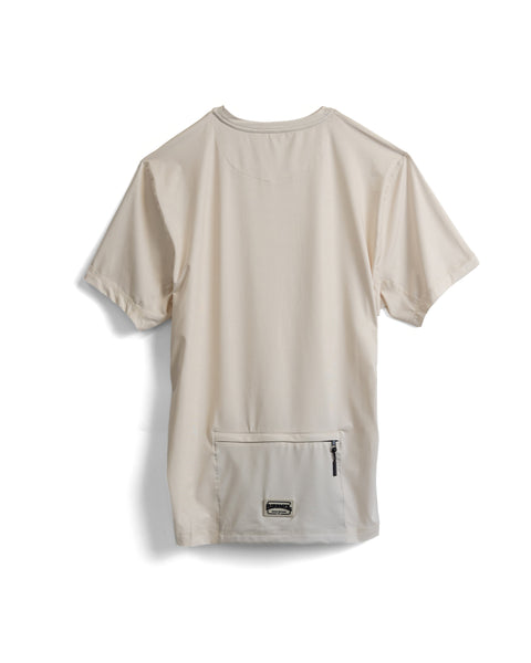 The Sunteez Short Sleeve - Bone is shown from the back, featuring a plain beige design with a horizontal zipper pocket near the bottom hem. Crafted from performance stretch fabric, it offers added comfort and flexibility.