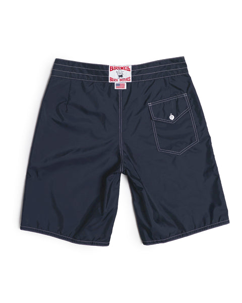 312 Boardshorts - Navy feature white stitching, a button-flap back pocket, and a distinctive white/red label on the waistband. These long-length navy boardshorts are proudly made in the USA for trusted quality.
