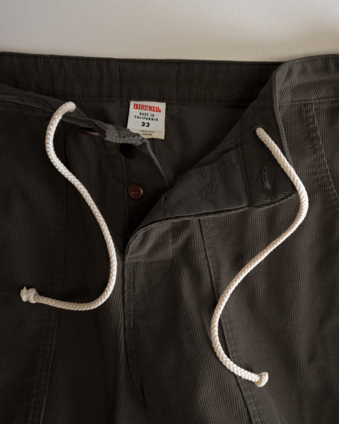 Close-up of brown Classic Corduroy Pants in SurfNyl corduroy with a drawstring waist, button fly, and interior size 32 brand label.
