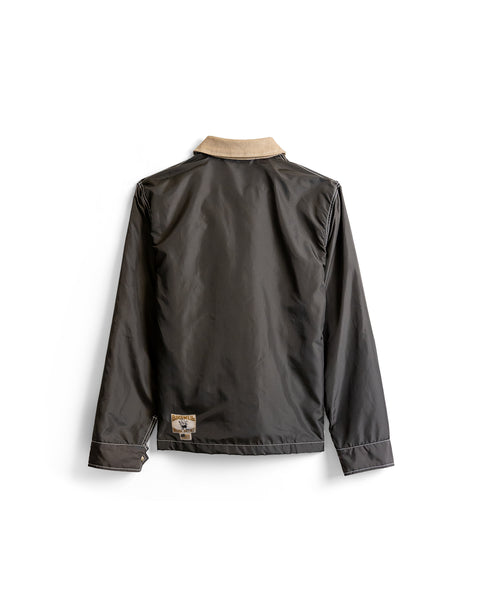 Back view of a dark brown Capistrano Jacket - Brown/Acorn with a tan collar and a small logo patch on the lower left hem.