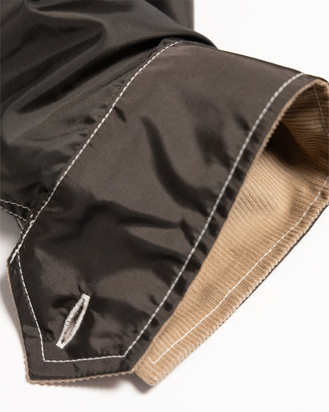 Close-up of a brown Capistrano Jacket - Brown/Acorn sleeve cuff featuring white topstitching and a tan ribbed lining.