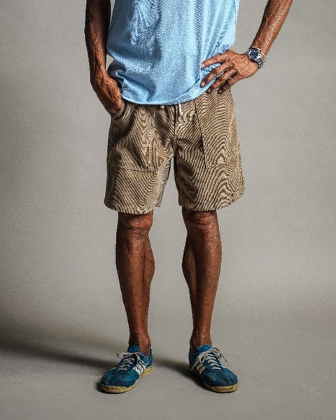 A person wearing sand Classic Corduroy Shorts with a drawcord waist and two large front patch pockets.