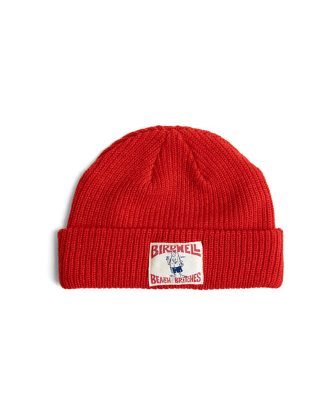 Bright red, ribbed License Plate Watchcap featuring a rectangular patch with a cartoon mascot and the text Birdwell Beach Britches.