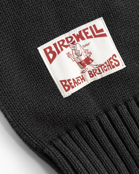 Black knit beanie with a 'Birdwell Beach Britches' label on a knitted black fabric.